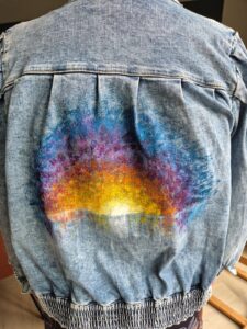 Handbeschilderd jeansjack met regenboog kleuren, intuïtief beschilderd
